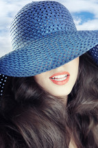 a woman in a blue straw sunhat 