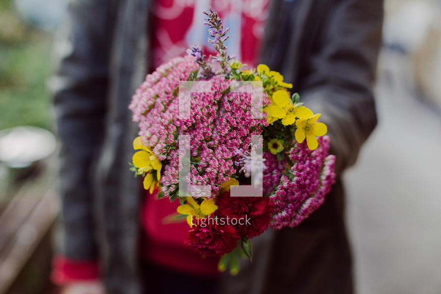 woman holding out a bouquet of flowers 
