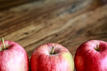row of apples on wood background 