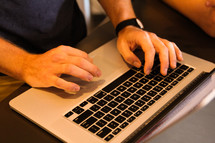 man typing on a laptop 