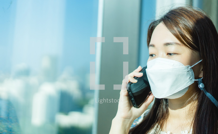 a woman wearing a face mask talking on a cellphone 