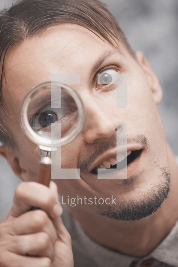 a man looking through a magnifying glass 
