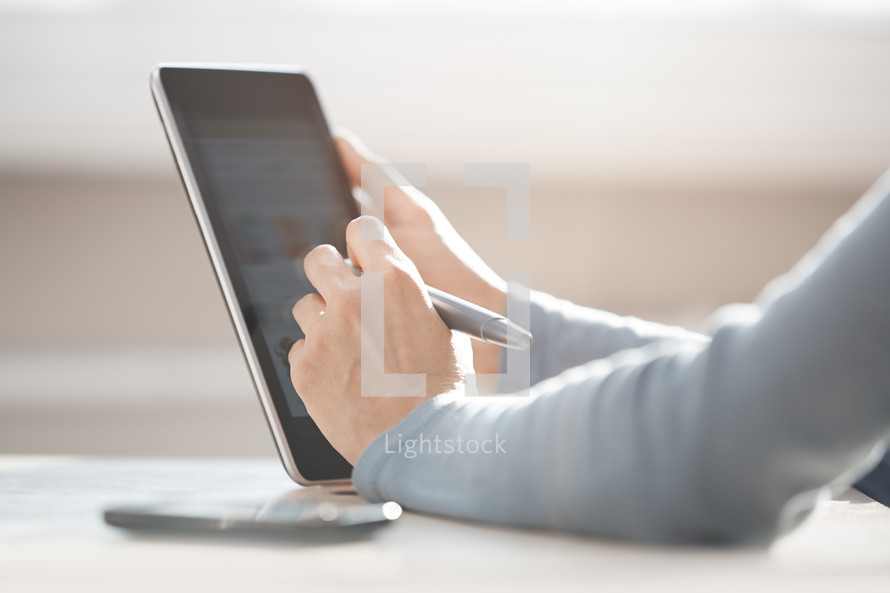person using a stylus on a tablet 