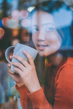 a young woman holding a coffee mug 