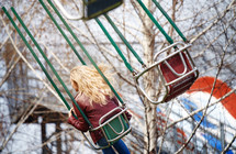 a woman on swinging chairs at a fair 