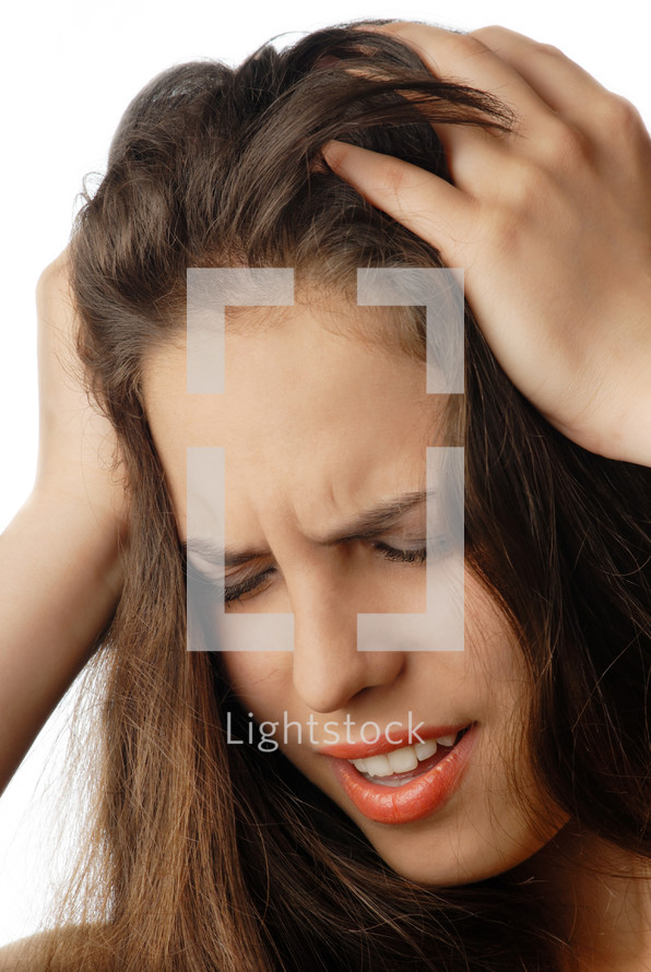 Woman suffering from headache and pressing her head by arms