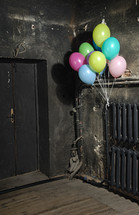 balloons on a radiator in a dark hallway 