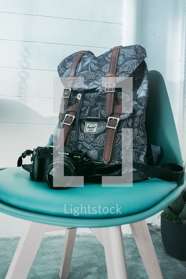 backpack and camera in a green office chair 