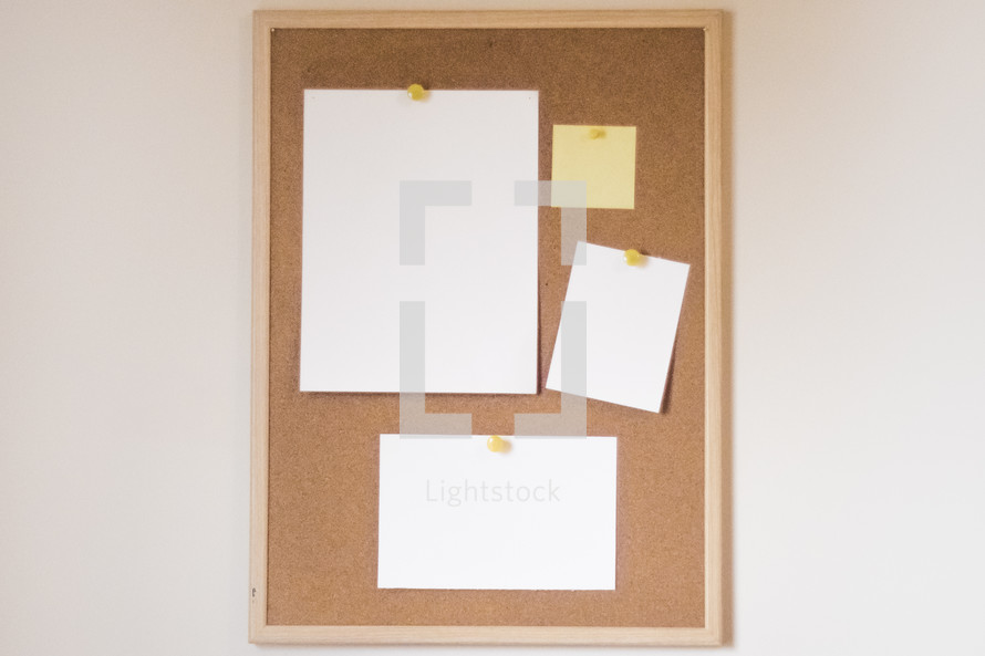 blank pieces of paper on a cork board 