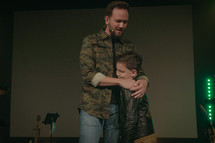 a minister holding a child and praying during a worship service 