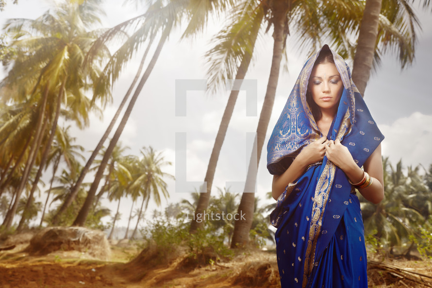 Hindu woman under palm trees 