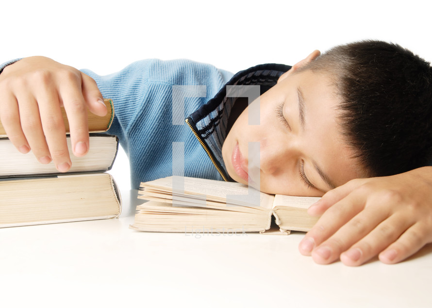 a kid sleeping on books 