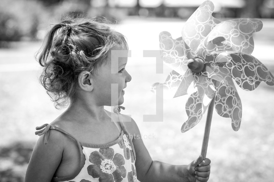 a toddler girl with a pinwheel 
