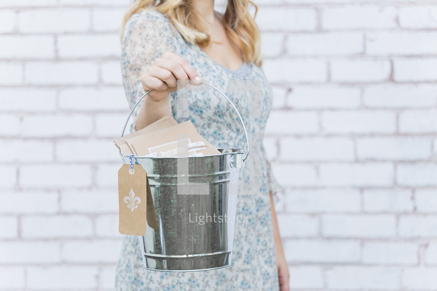 woman holding a pail of greeting cards 