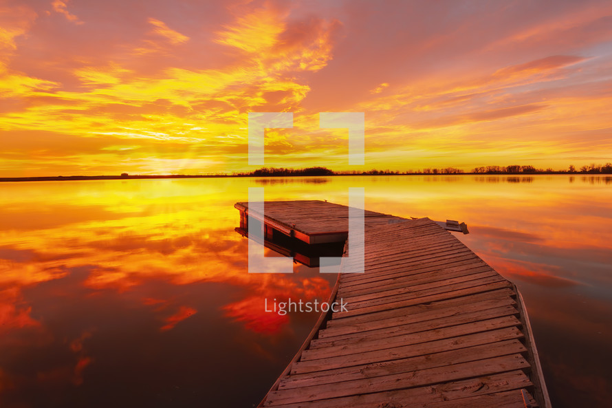 A brilliant colorful sunrise as the fishing dock awaits the sun