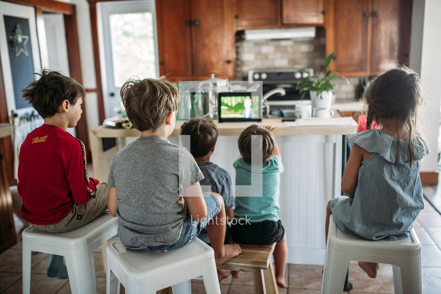 children doing a video conference in a kitchen 