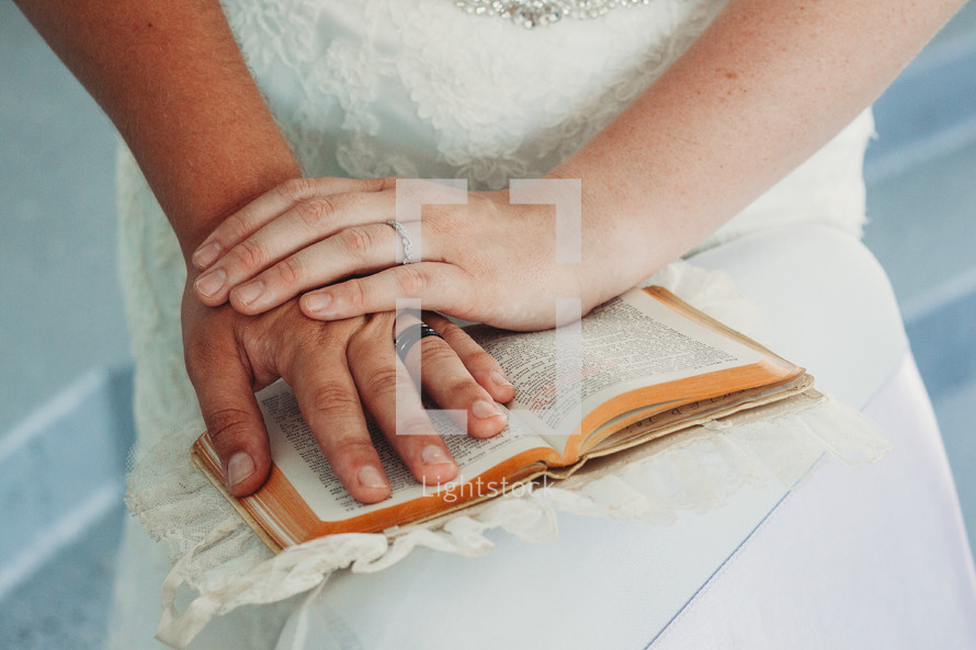 bride and groom with their hands on a Bible 