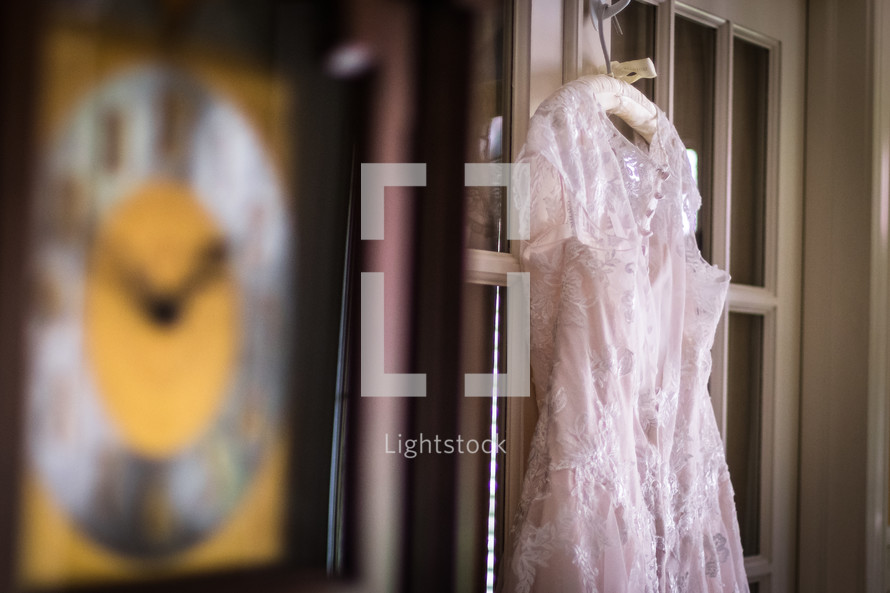 bridal gown hanging on a door 