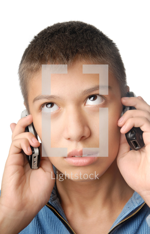 Boy with two cell phones on a white background