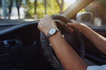man's hands on a steering wheel 