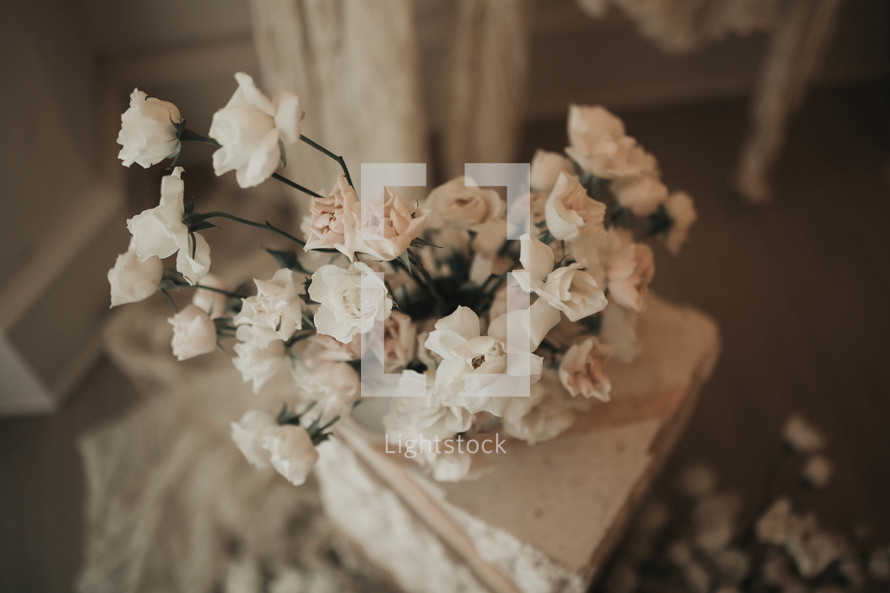 small white flowers near a marble pillar