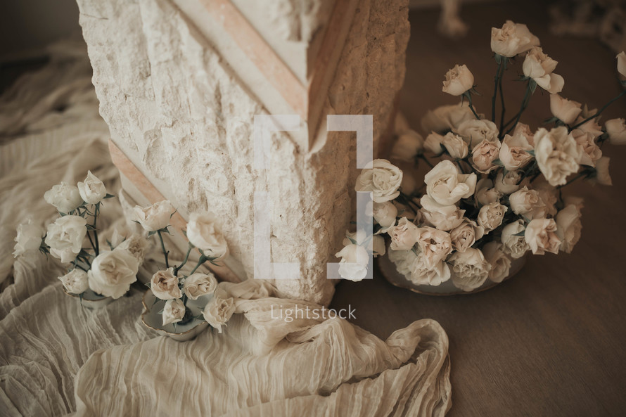 small white flowers near a marble pillar