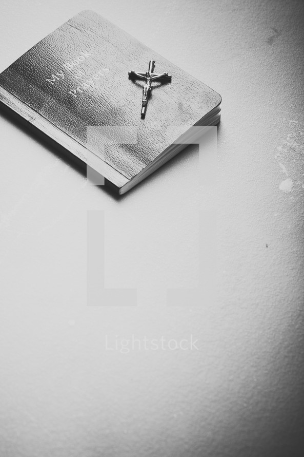Silver crucifix on top of prayer book.
