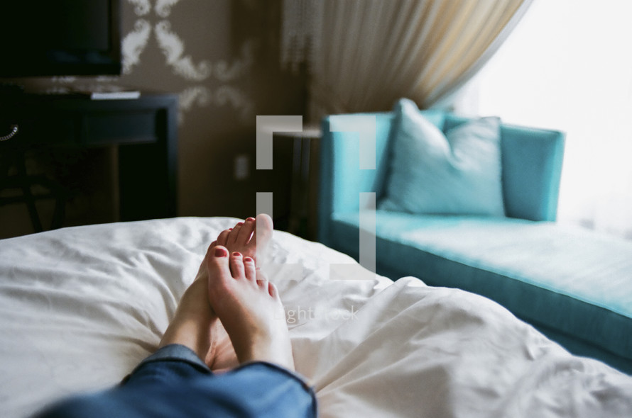 woman's feet lying in bed 