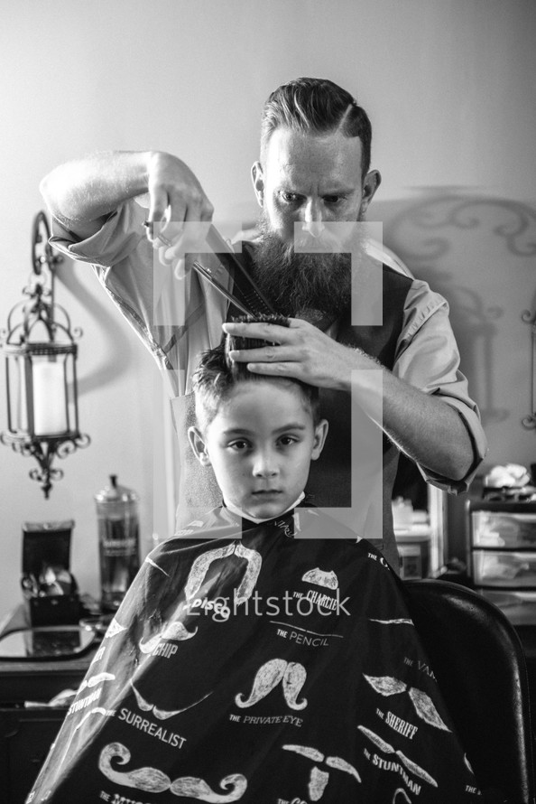 a boy at the barber shop getting a hair cut 