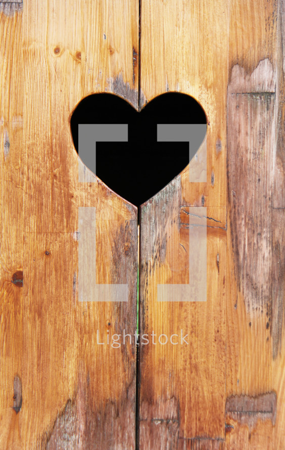 Heart shape cut out in wood background 