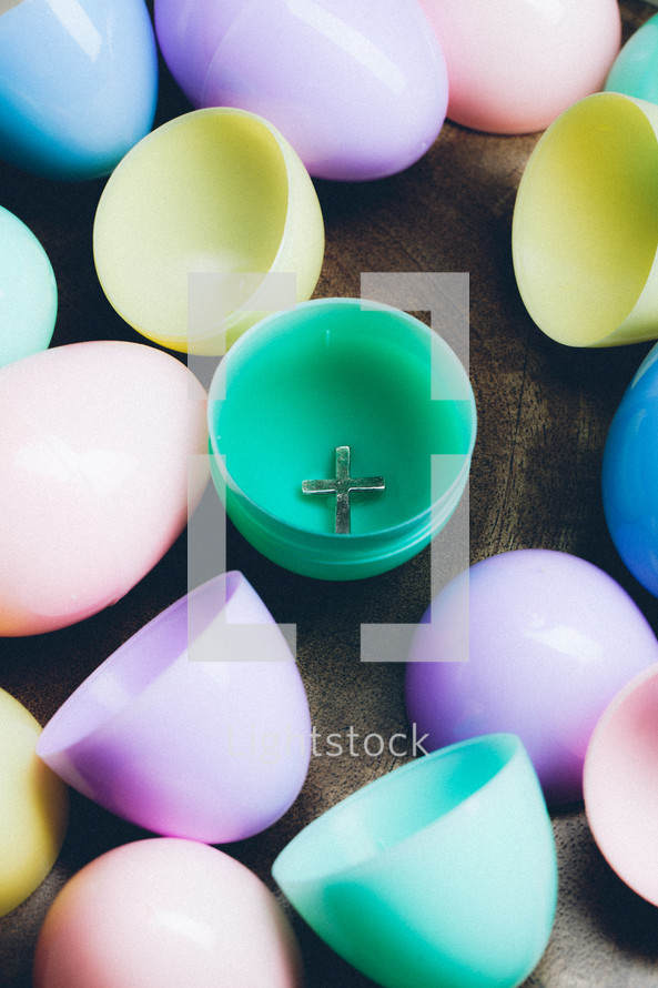 Silver cross inside colorful plastic Easter egg.