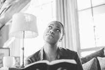woman looking up to God while reading a Bible 