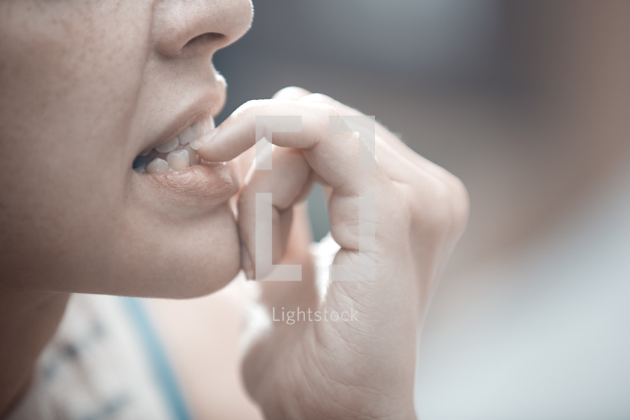 nervous woman biting her nails 