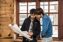 two men looking over blueprints 