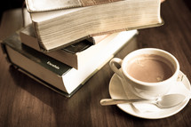 stack of books and a coffee cup with spoon