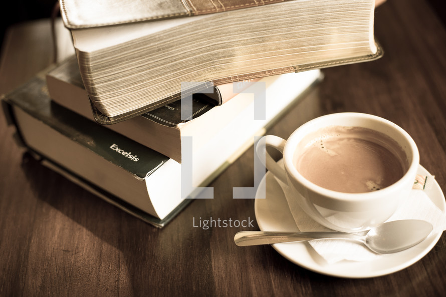 stack of books and a coffee cup with spoon