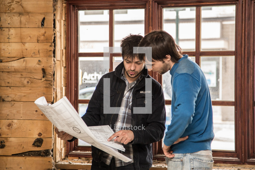 two men looking over blueprints 
