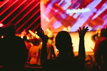 silhouette of raised hands at a contemporary worship service 