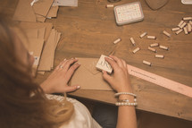 A woman at a desk working with crafting stamps.