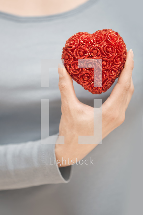 a woman holding a red heart 