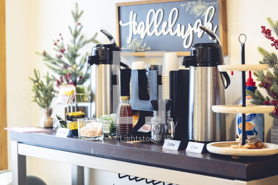 Coffee bar at church with a "hallelujah" sign and Christmas trees