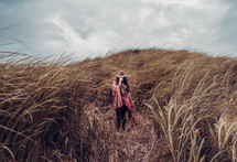 portrait of woman in a field of tall brown grasses 