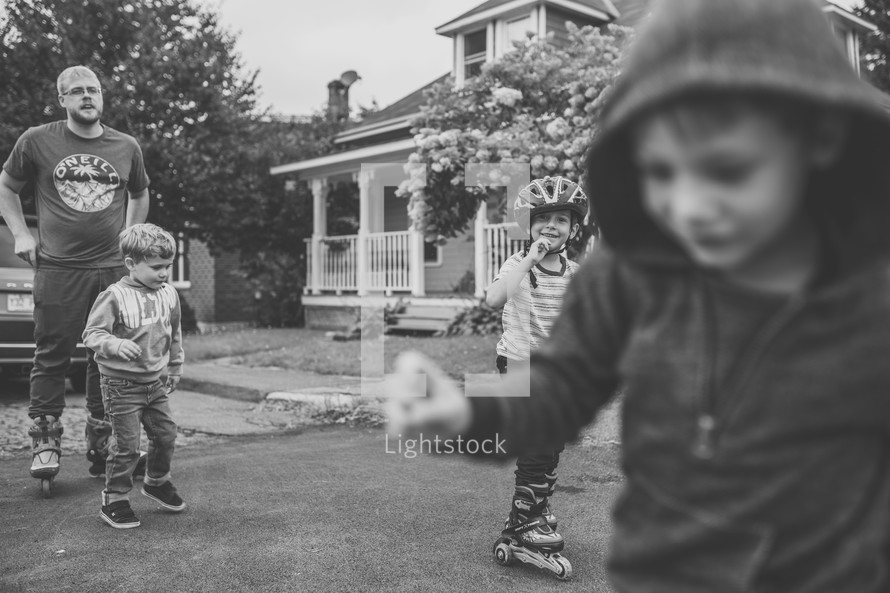 brothers and dad playing in a front yard 