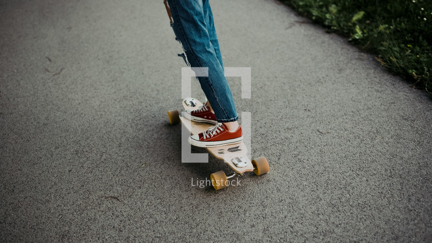 legs of a young woman on a skateboard