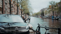 a woman parked along the edge of a canal 