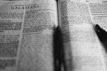pen lying on a Bible open to Galatians 
