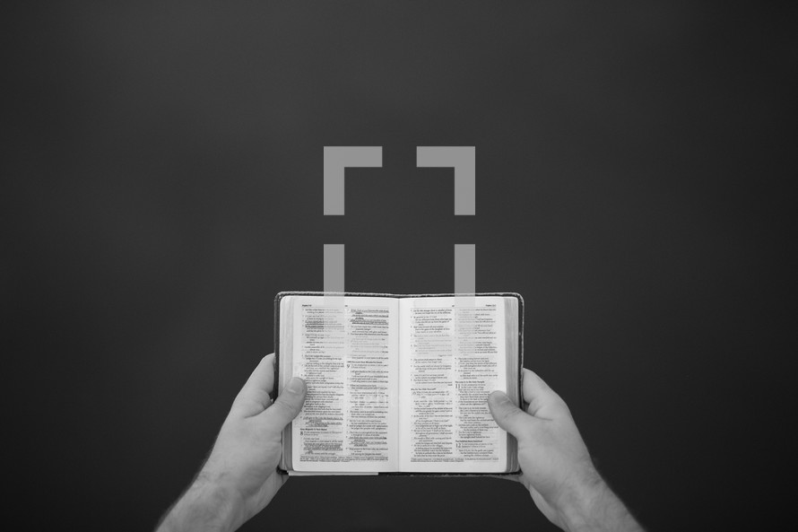 man holding a mini Bible 