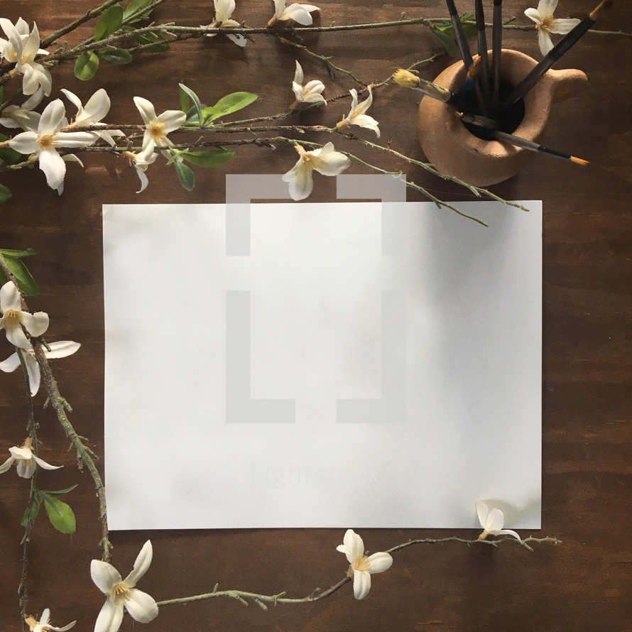 blank white paper and white flowers on vines 