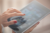 a woman touching an iPad screen 