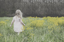 toddler girl in a field of tall grasses and wildflowers 